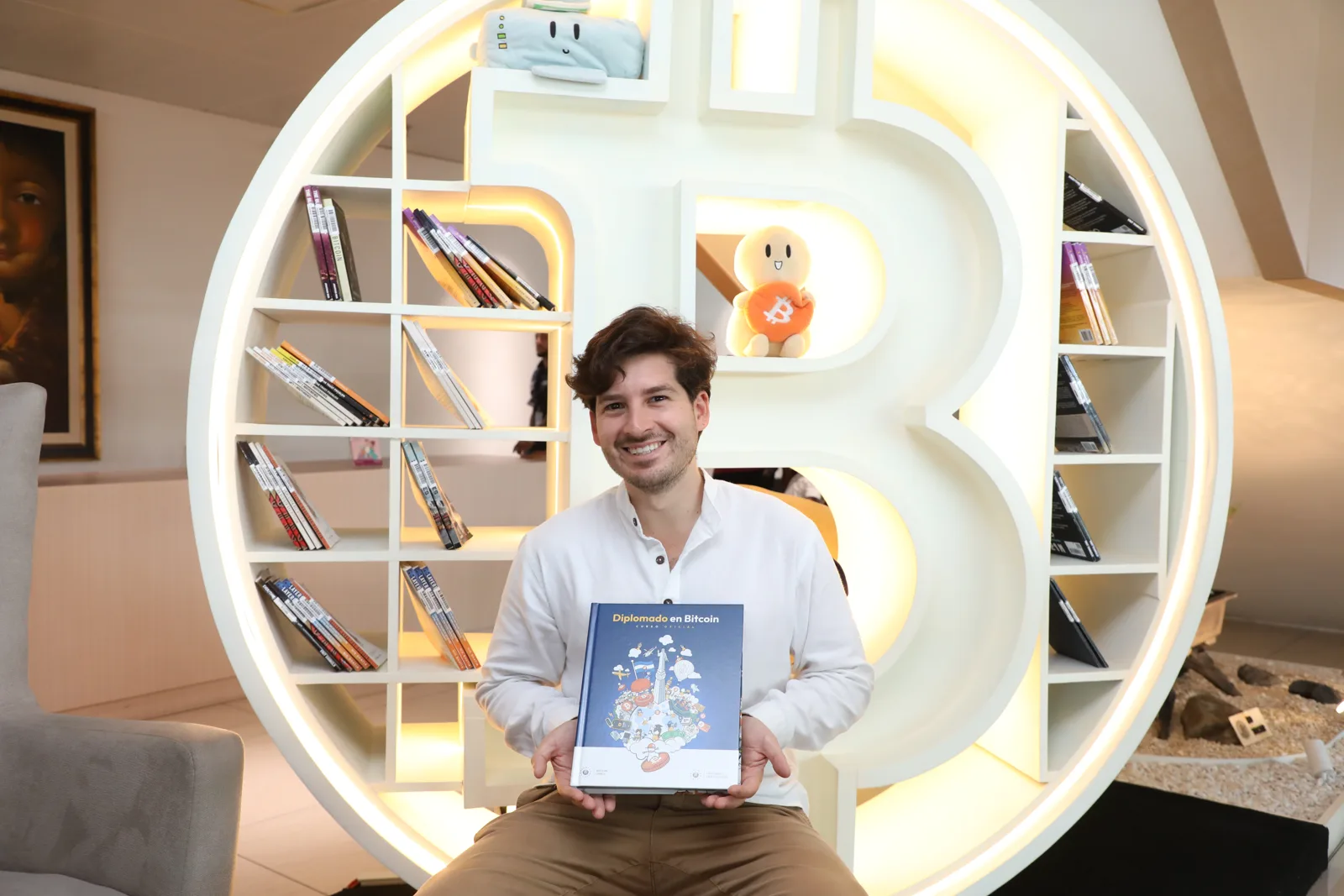 Nelson Inno, education consultant, holding Diplomado en Bitcoin, the official course book he designed with his team